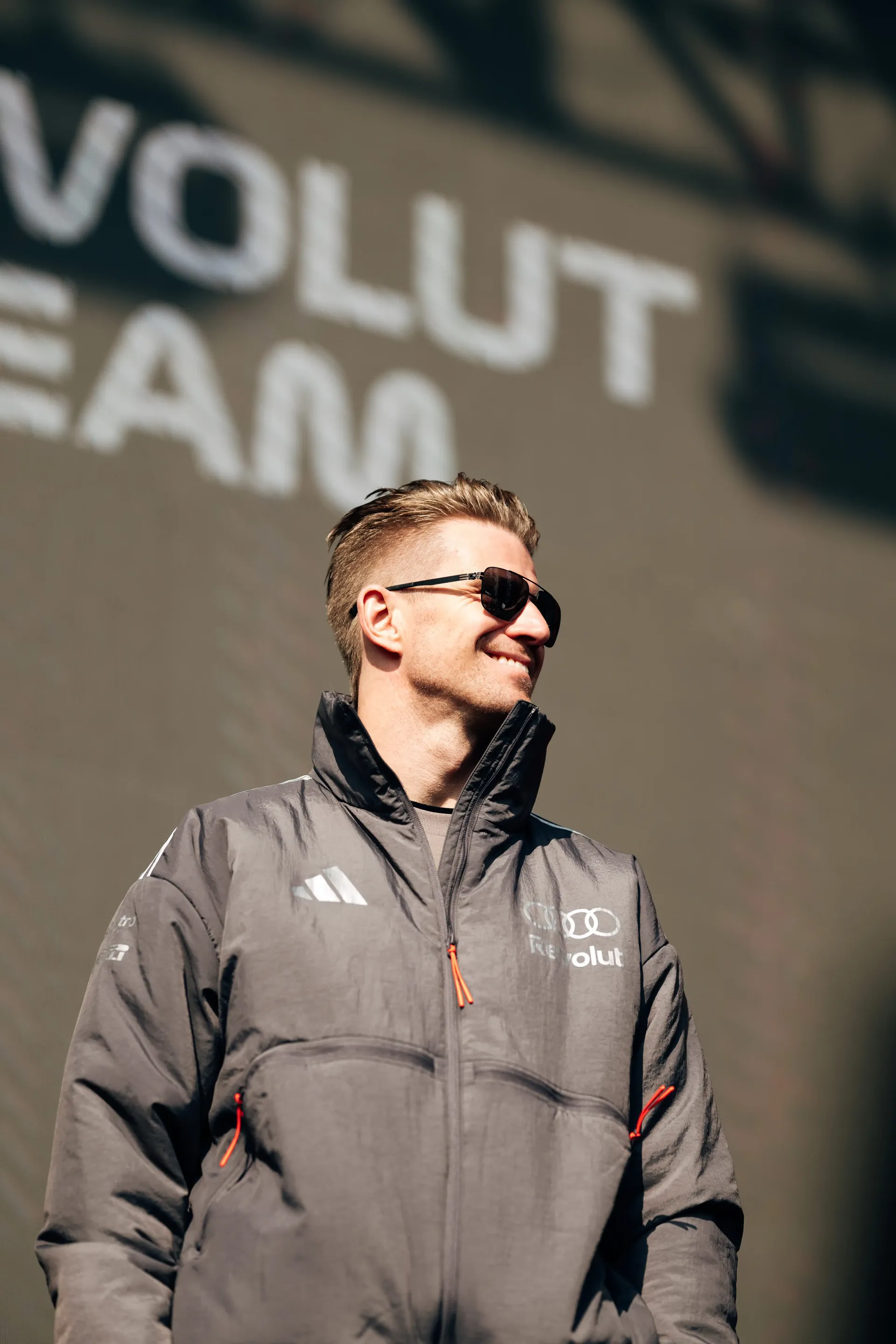 Audi Revolut F1® Team driver Nico Hulkenberg  standing in front of a sponsor backdrop during a paddock appearance.