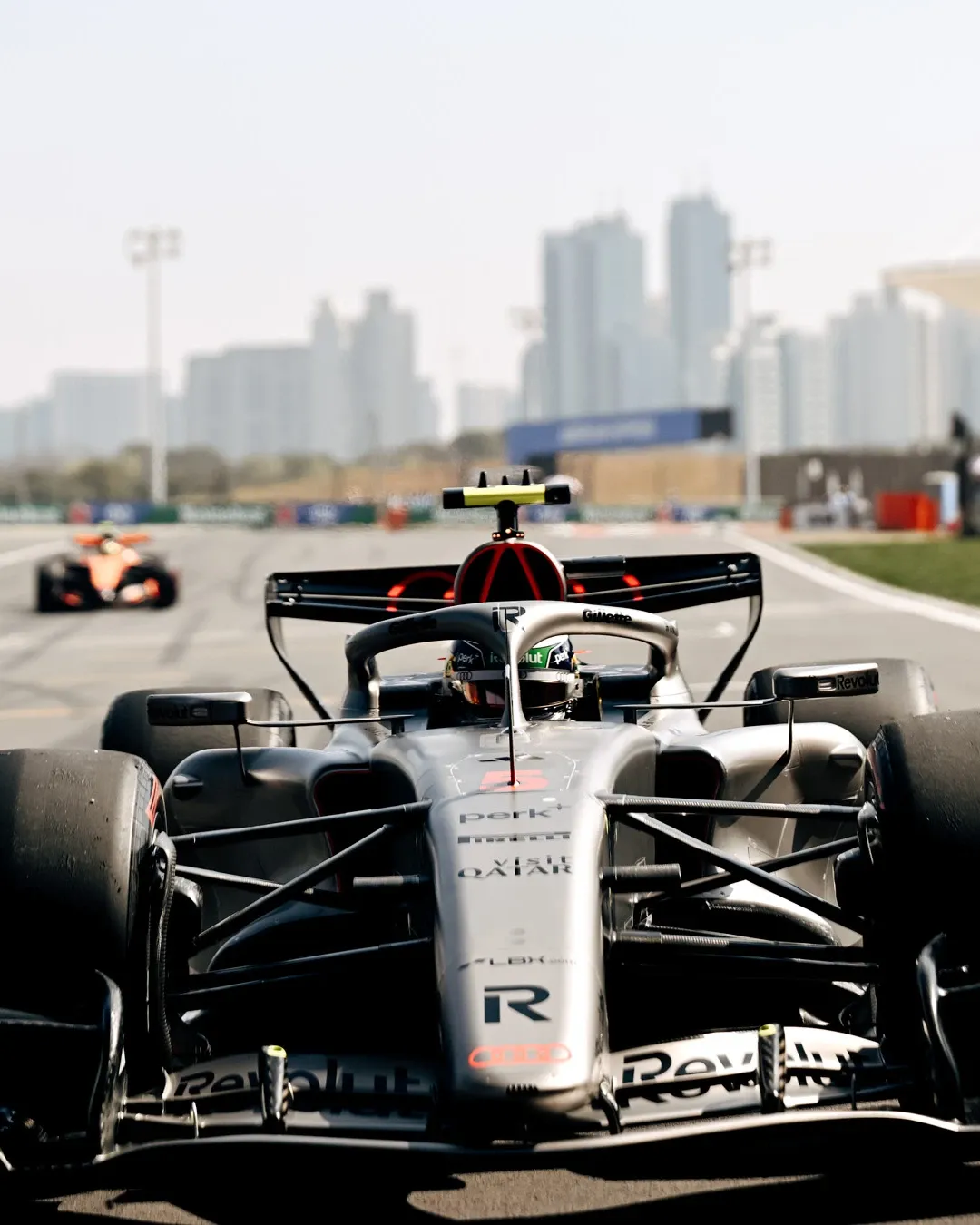 Gabriel Bortoleto drives the Audi Revolut F1® Team car on track in Shanghai with the city skyline visible in the background.