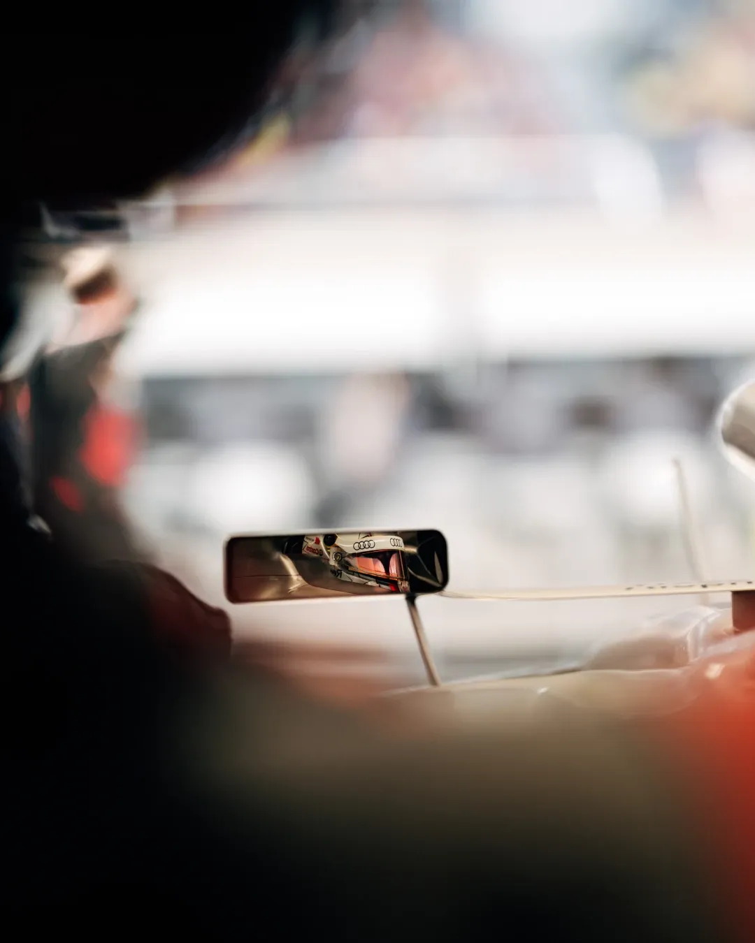 Nico Hulkenberg’s helmet is reflected in the side mirror of the Audi Revolut F1® Team car during garage preparations in Shanghai.