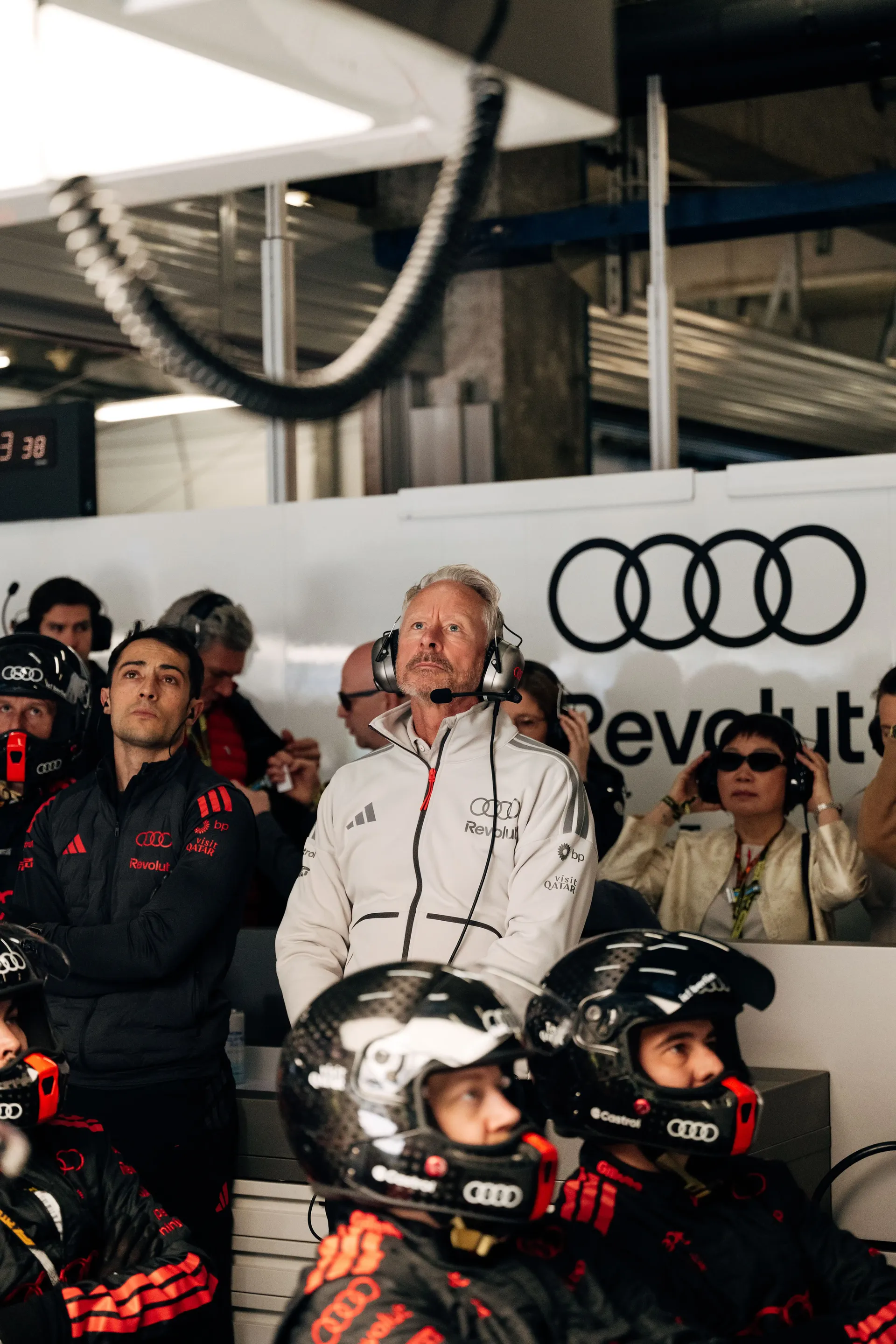 Audi Revolut F1® Team mechanics and engineers observing the session together inside the Formula 1 garage.