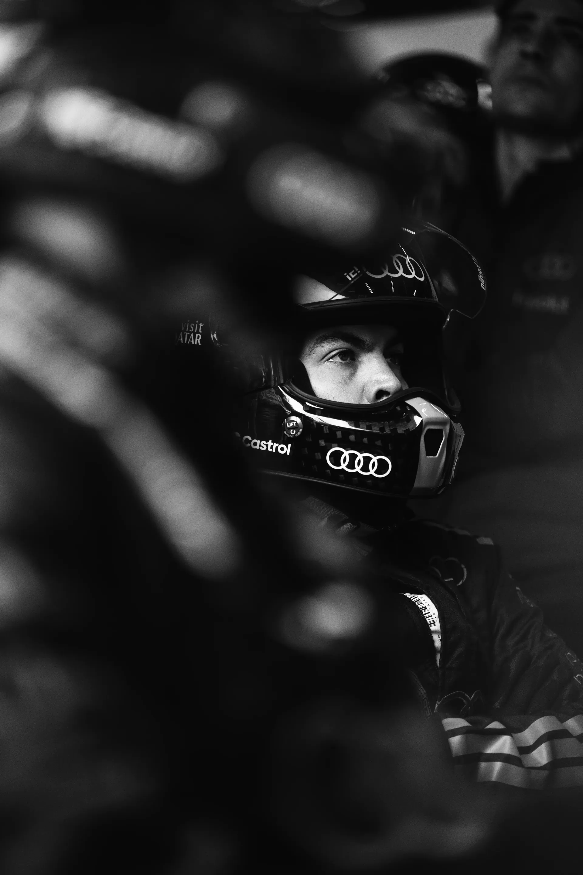 Audi Revolut F1® Team mechanic wearing a helmet sitting in the cockpit during preparations in the garage.