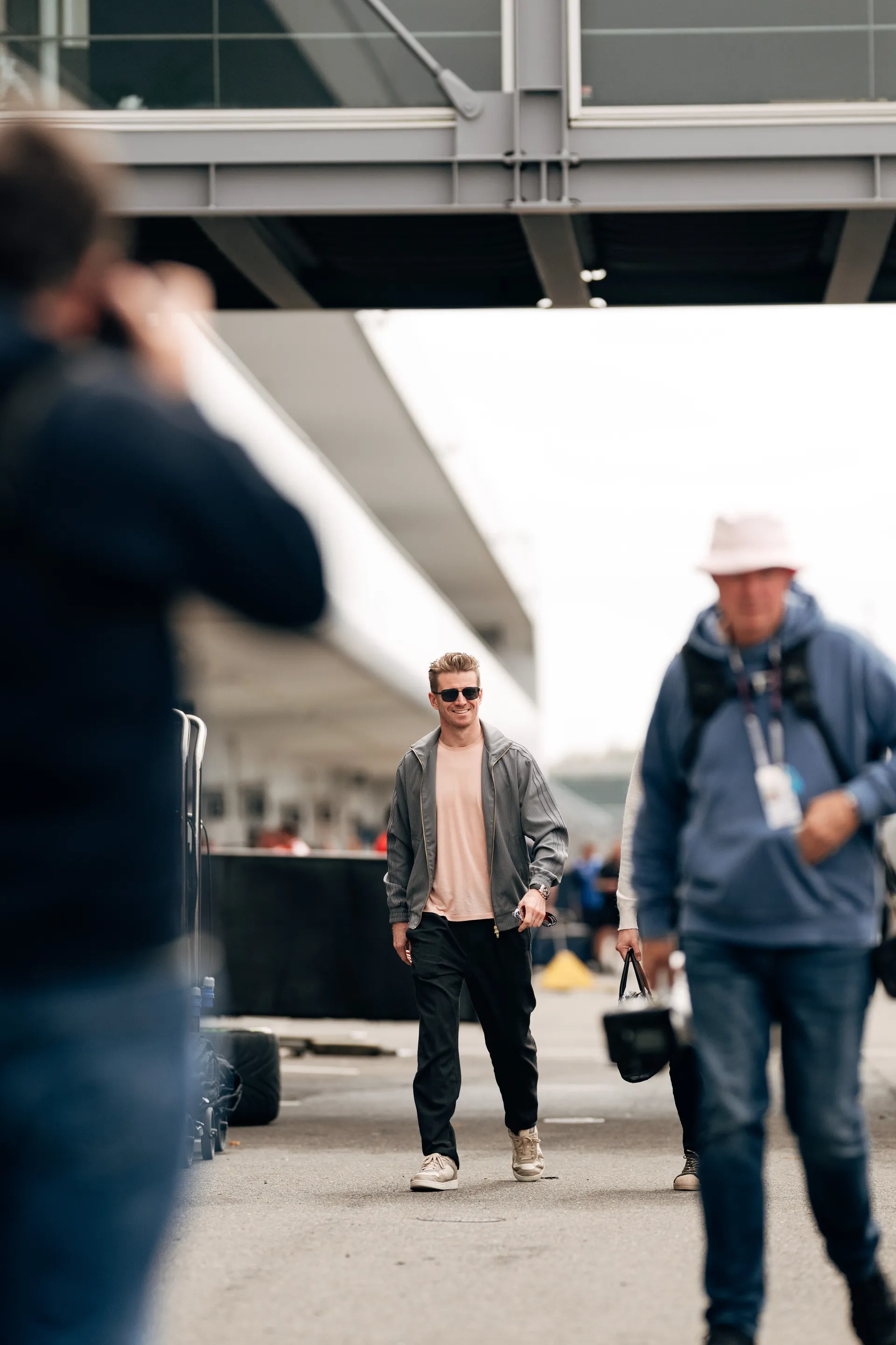Nico Hulkenberg walks through the paddock smiling during the Suzuka race weekend.