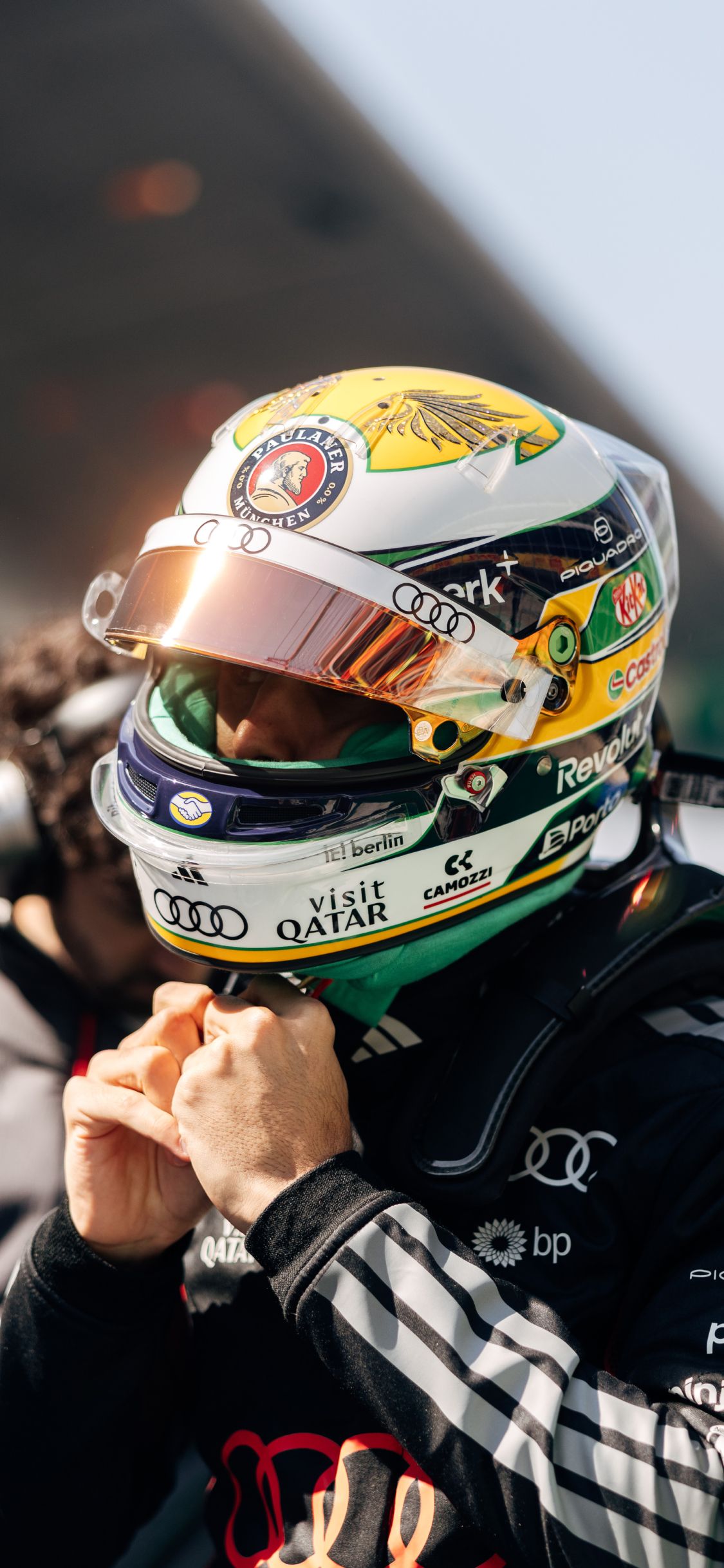 Close up of Gabriel Bortoleto fastening his helmet strap in Audi Revolut F1® Team race kit before the Chinese Grand Prix.