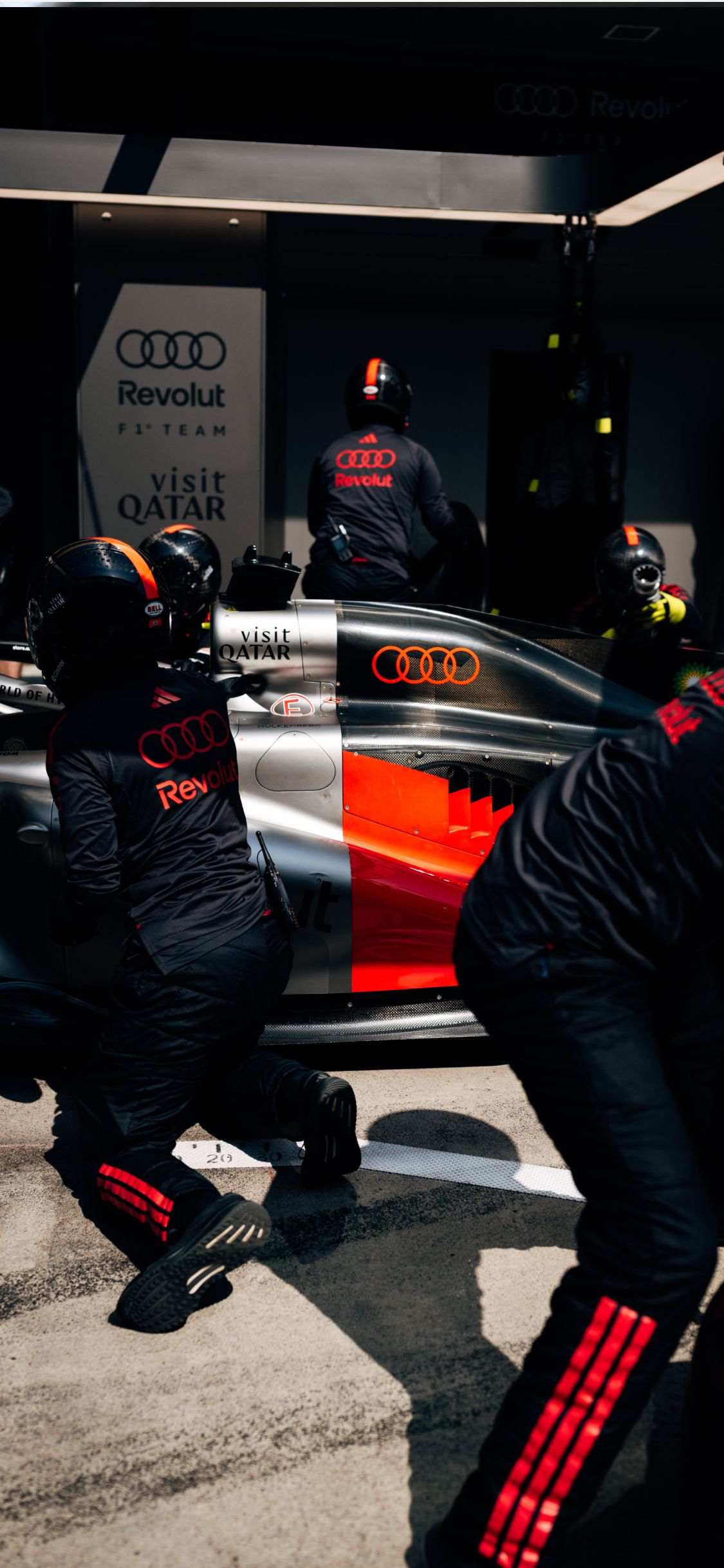 Audi Revolut F1® Team pit crew work on the car in the garage during the Chinese Grand Prix weekend.