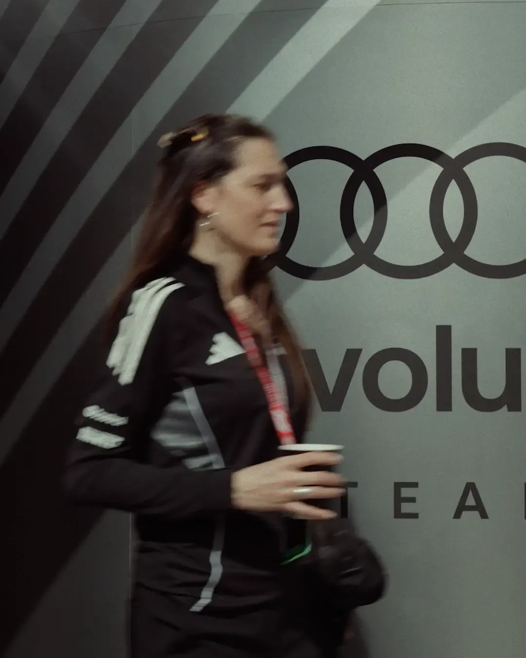 Formula 1 Racing Team walk through the paddock, all in Audi Revolut F1® Team kit, walking busy in front of Audi Revolut F1 Adidas Logowall