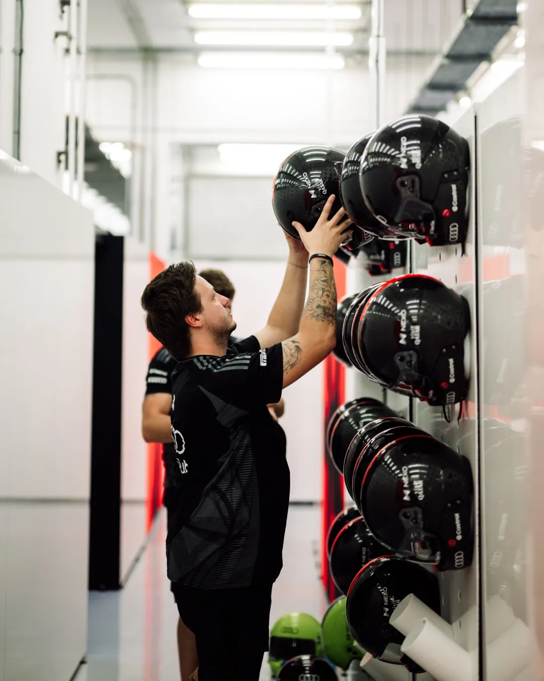 Audi Revolut F1® Team crew member places helmets on the garage wall during Bahrain testing