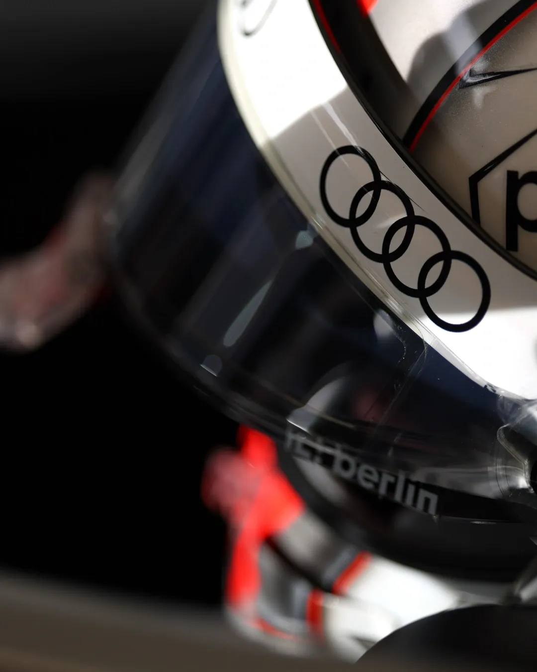 Close up of a racing helmet visor with the Audi rings, light reflecting on the face shield.