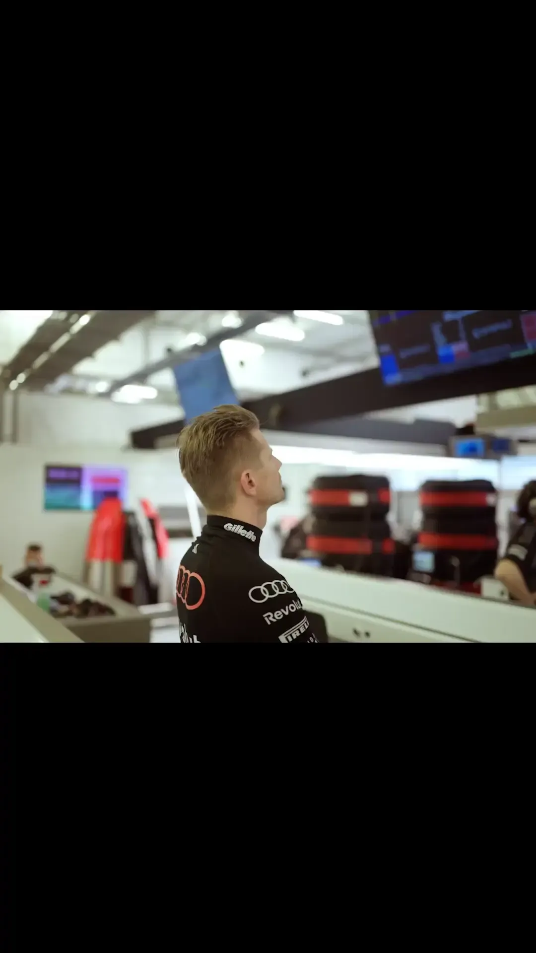 Side view of the Formel 1 athlete Nico Hulkenberg from the Audi Revolut F1® Team, inside the technic room, watching closely the screens