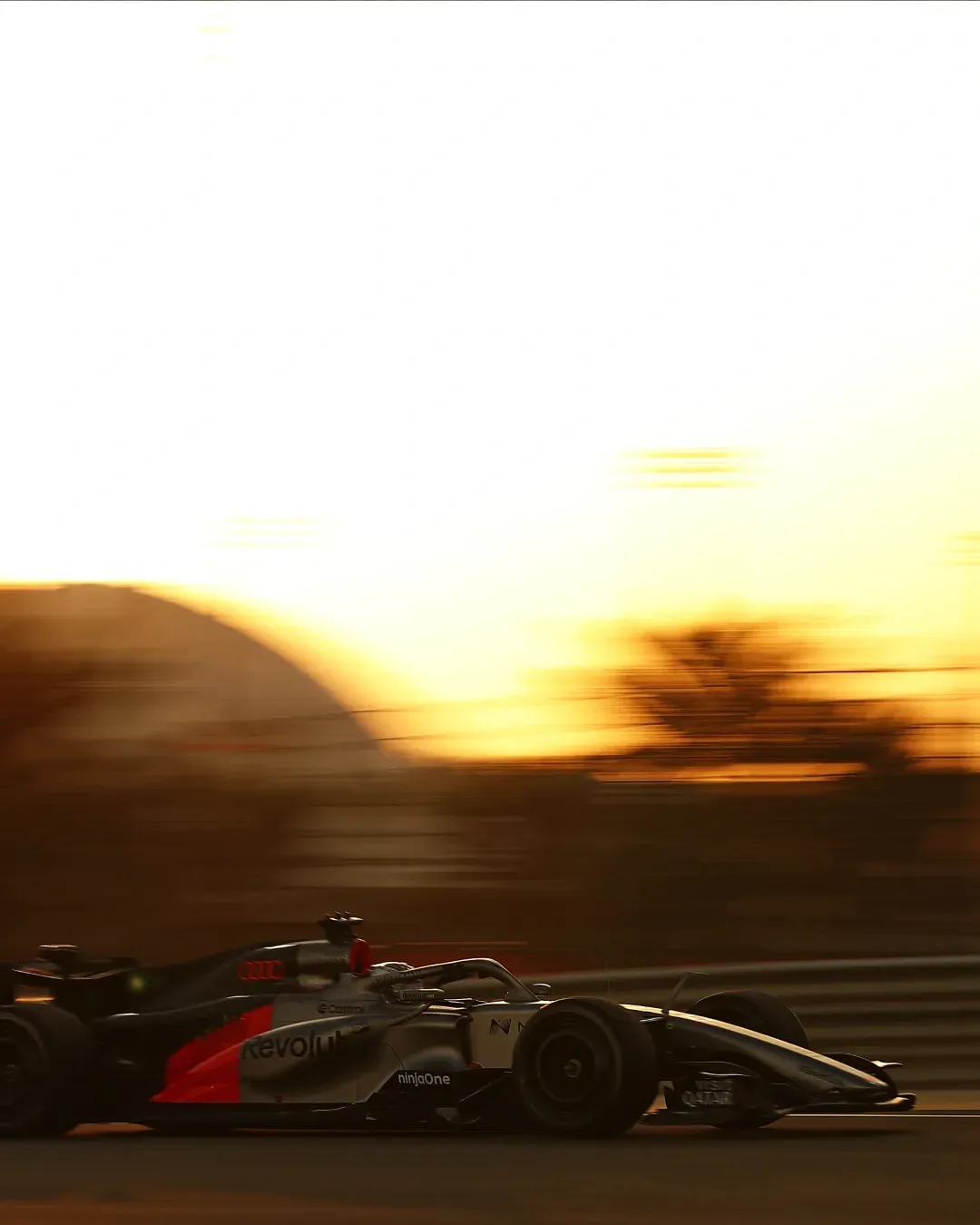 Side view of the car speeding past at sunset with motion blur.