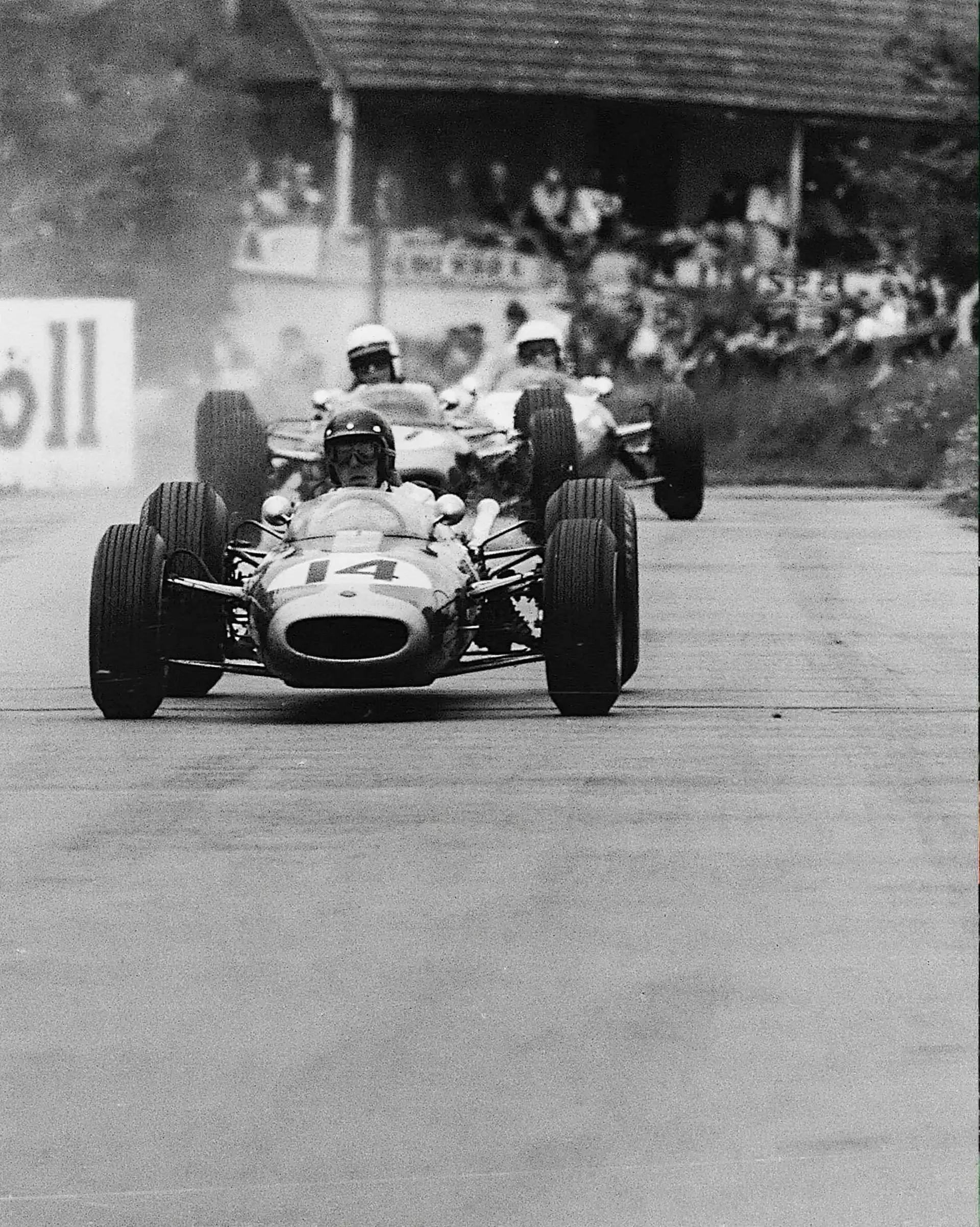 Historic Austrian Grand Prix race at Zeltweg Air Base with multiple competitors in frame.