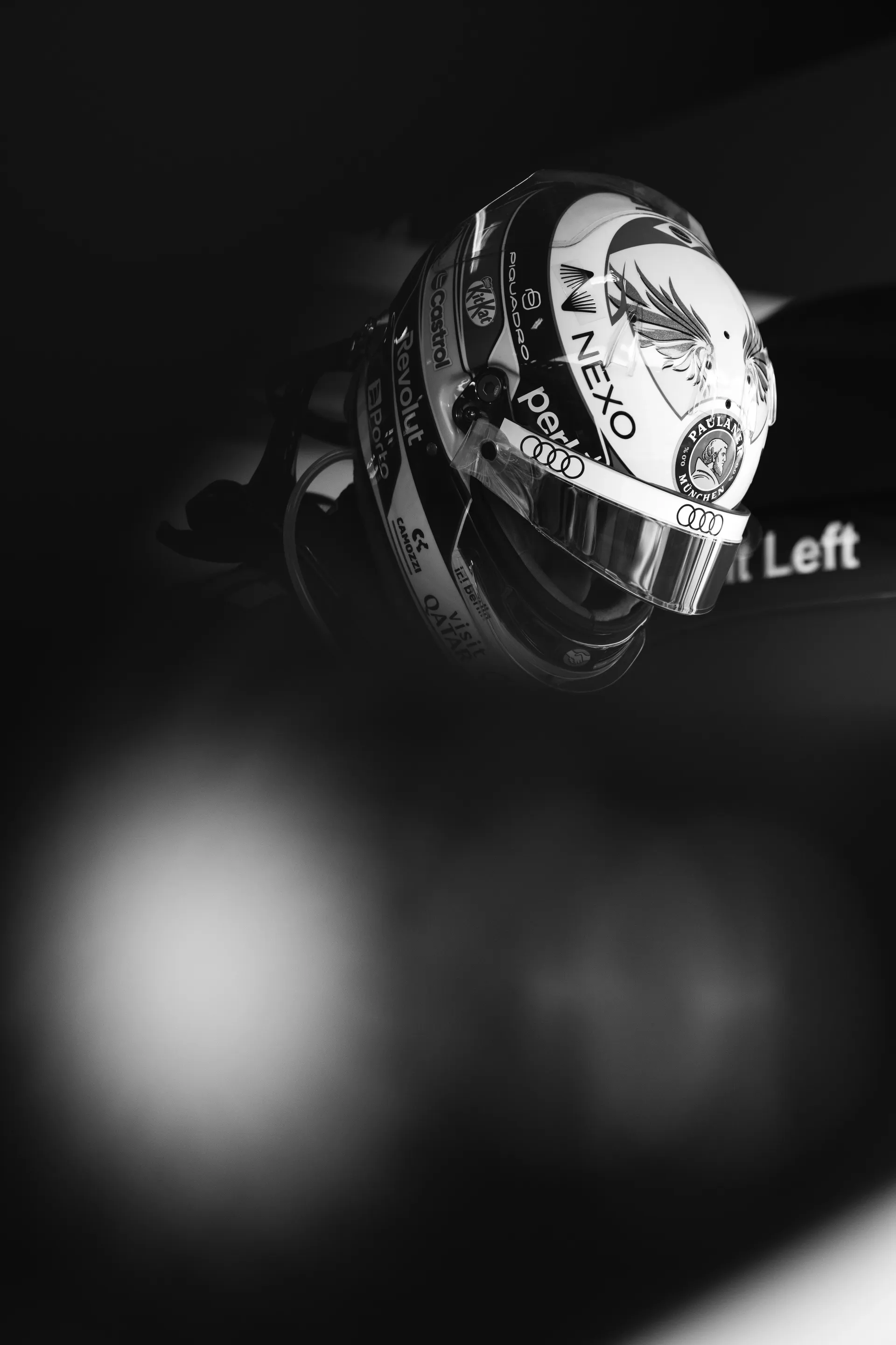 Artistic black and white close up of an Audi Revolut F1® Team driver Gabriel Bortoleto helmet resting in the garage.