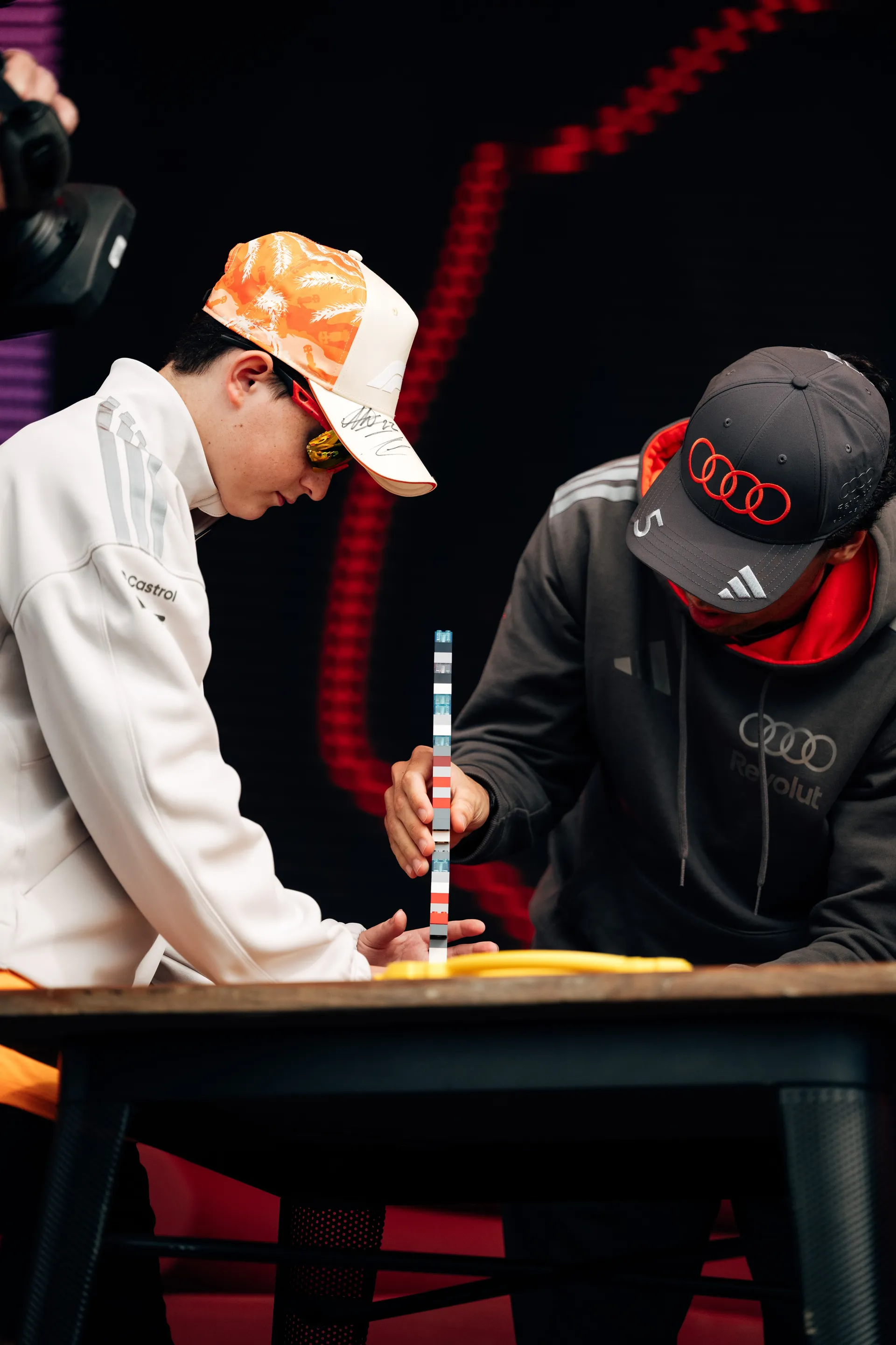 An Audi Revolut F1® Team driver Gabriel Bortoleto  signs a cap for a young fan during an interactive stage moment in Melbourne.